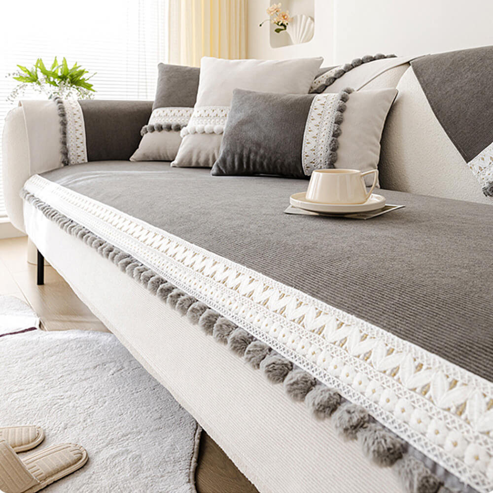 Navy corduroy couch cover with pom-poms, close-up of soft, ribbed fabric texture.