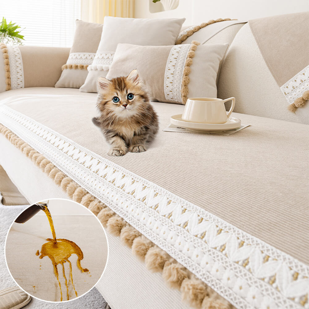 Lifestyle image of a pet relaxing on a beige corduroy couch cover with pom-poms.