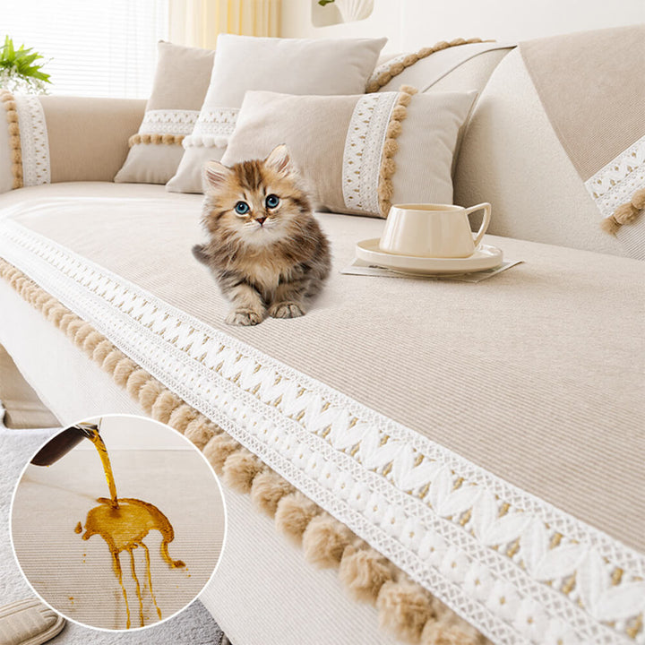Lifestyle image of a pet relaxing on a beige corduroy couch cover with pom-poms.