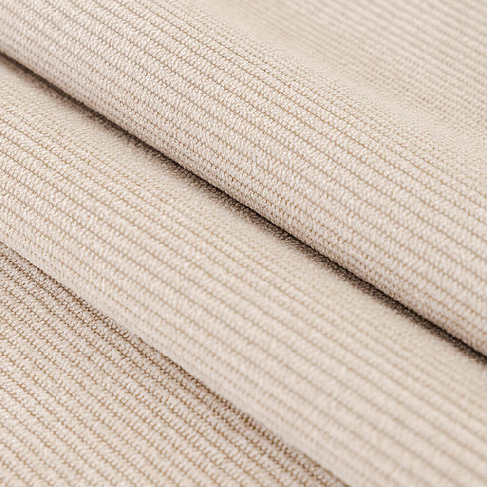 Close-up of a pom-pom detail on a washable corduroy couch cover, showing texture.