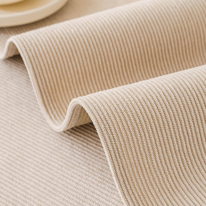 Folded blue corduroy couch cover, displaying its water-resistant and washable qualities.