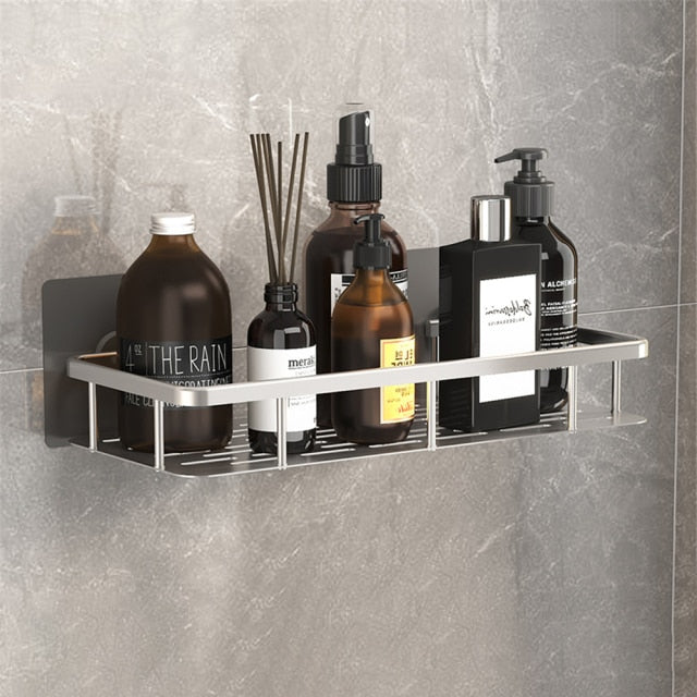 Metal shower organizer shelf installed in a modern bathroom, holding various toiletries.