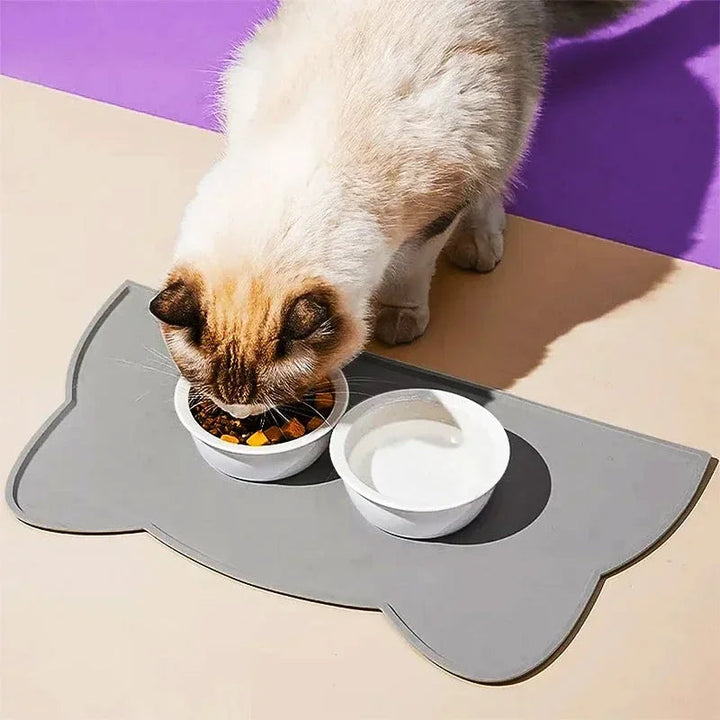 Two pet bowls on a large, grey, non-slip silicone feeding mat for cats and dogs