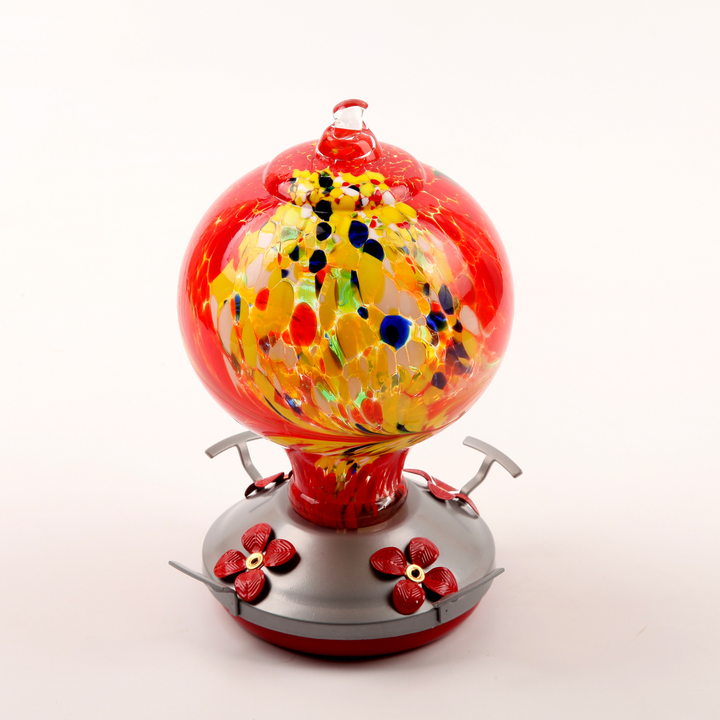 Detailed view of Ocean Blue Hand Blown Glass Hummingbird Feeder hanging in a sunny garden oasis