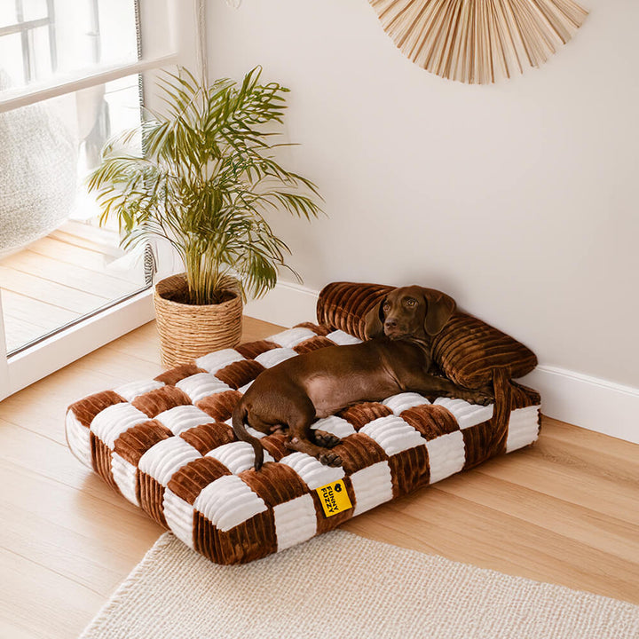 Soft orthopedic dog bed with a distinct chessboard design and a supportive pillow.