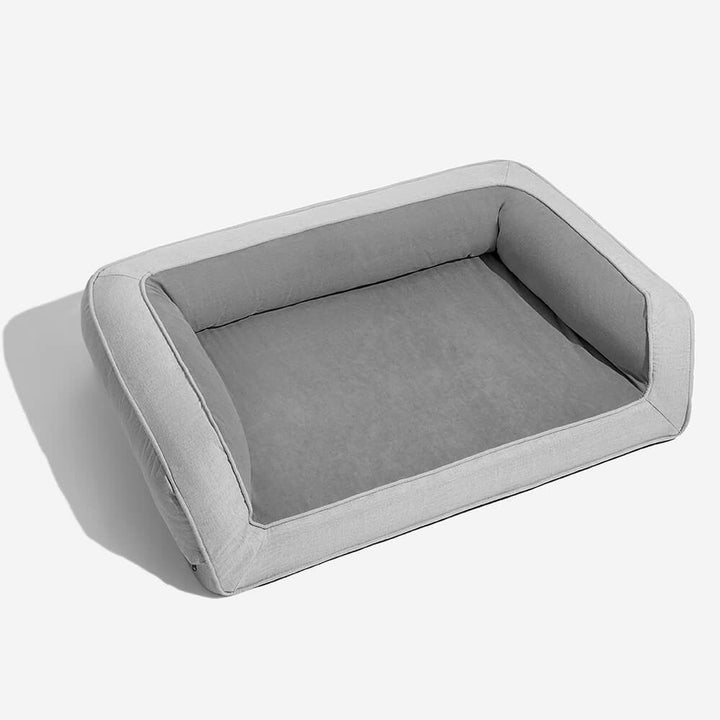 High-angle view of a grey orthopedic dog bed with bolsters, designed for maximum pet comfort and support.