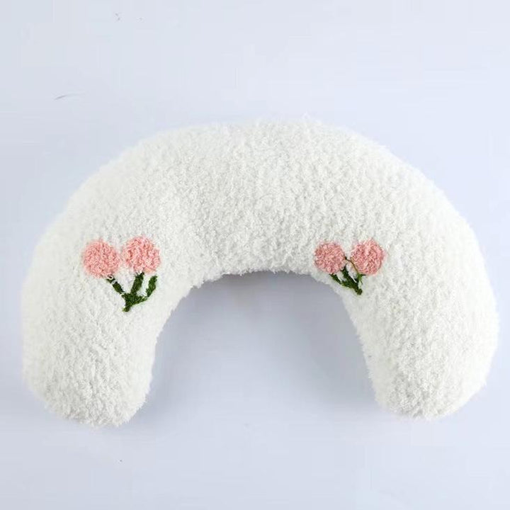 Dog relaxing in a grey U-shaped orthopedic bed, showing plush comfort and joint support.