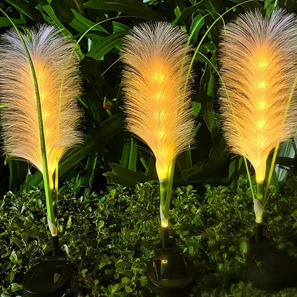 Bright solar reed lights enhancing a garden's ambiance, perfect for outdoor landscape lighting.