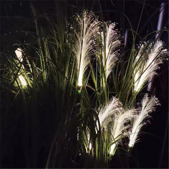 Outdoor solar reed light glowing warmly amidst garden foliage, perfect for evening decor.