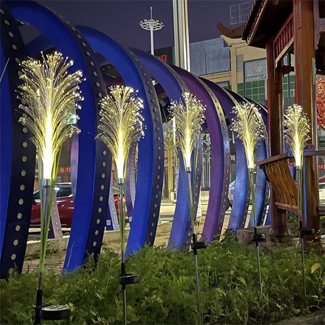 Garden pathway at night, softly lit by a row of outdoor solar power reed lights.