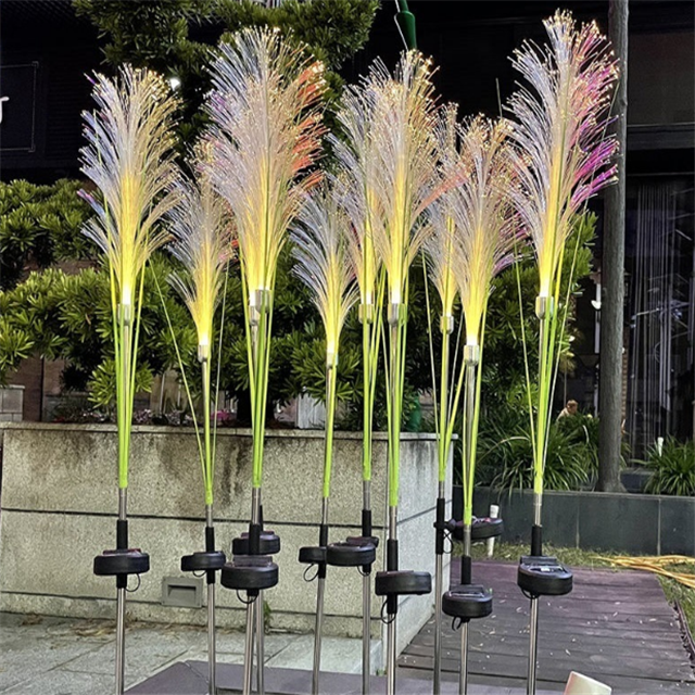 Solar reed light standing tall in a flower bed, a beautiful and practical garden decor item.