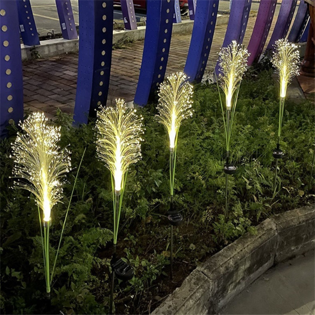 Dynamic shot of solar reed garden light in action, creating a firework display on the lawn.