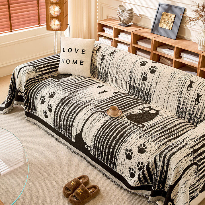 Multipurpose Paw Print Chenille sofa cover draped over a couch, offering pet protection.