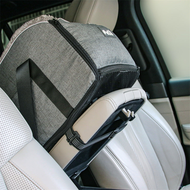 Small dog comfortably seated in soft car armrest booster, a safe pet travel solution.