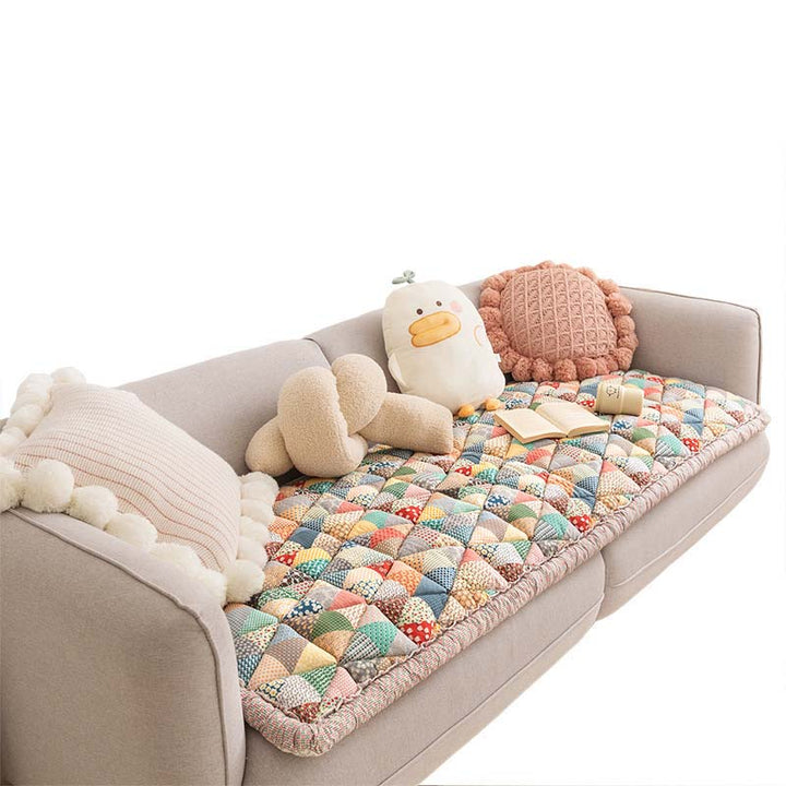 Detail of the secure fit of a non-slip pet-friendly cotton couch cover on an armrest