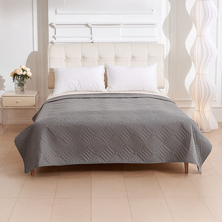 A cat napping on a black Pet Proof Water-Resistant Blanket Bed Cover, keeping furniture clean.