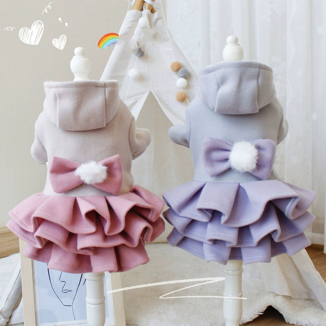 Back view of a small dog in a pink fleece dress jacket with a bow, cozy winter outfit