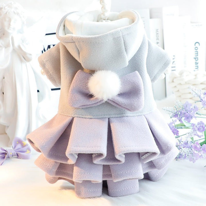 Adorable small dog in a pink fleece dress jacket with a decorative bow, cute pet clothes