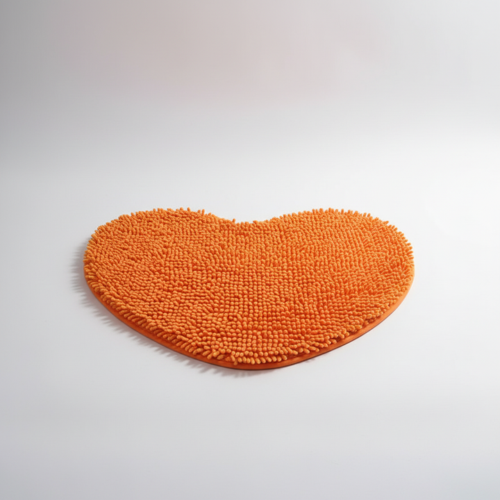 Yellow heart-shaped plush bath mat. Super soft, absorbent, and non-slip. Ideal for a safe and comfortable home spa.