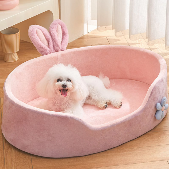 Pink pet bed with cute bunny ears and flower decor, a soft cozy retreat for cats or small dogs.
