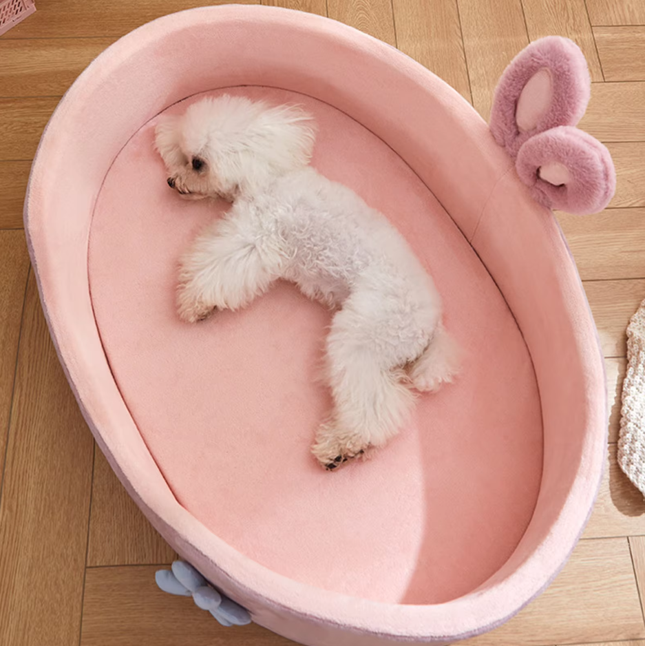 Cozy pink pet bed featuring adorable bunny ears and a floral accent, perfect for cat or dog comfort.
