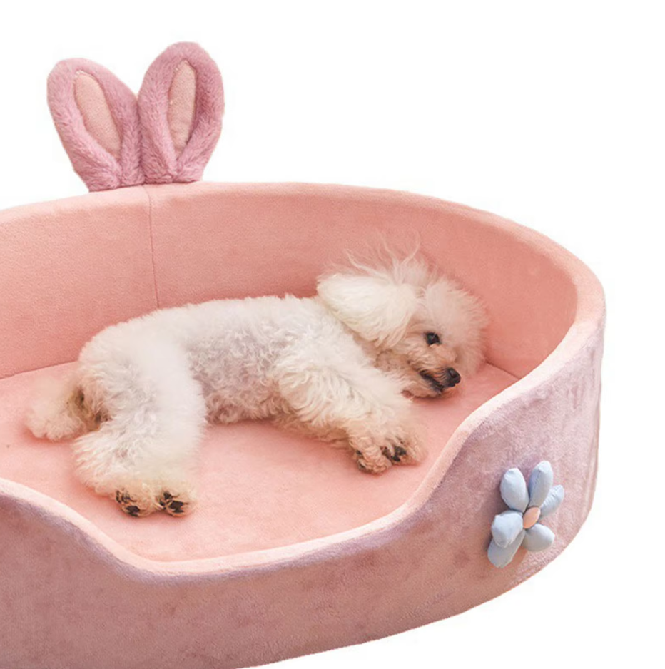 Luxurious pink dog bed with decorative bunny ears and a flower, offering ultimate pet comfort and style.