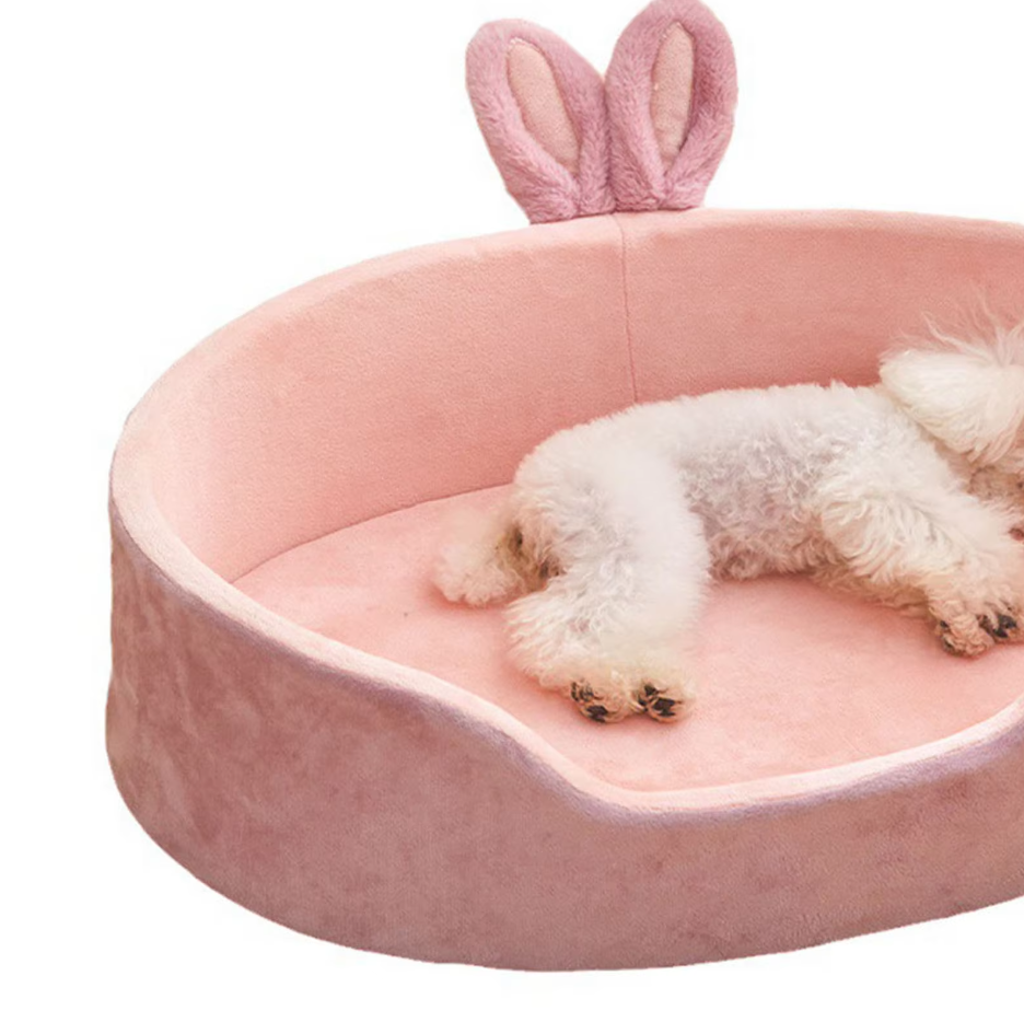 Pet accessory: pink pet bed with fluffy bunny ears and flower detail for a pampered cat or small dog.