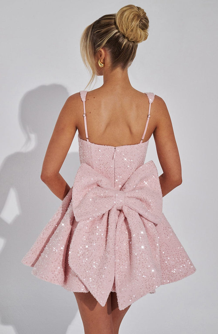 Elegant short white sequin party dress with a flared skirt and prominent bow detail for special occasions.