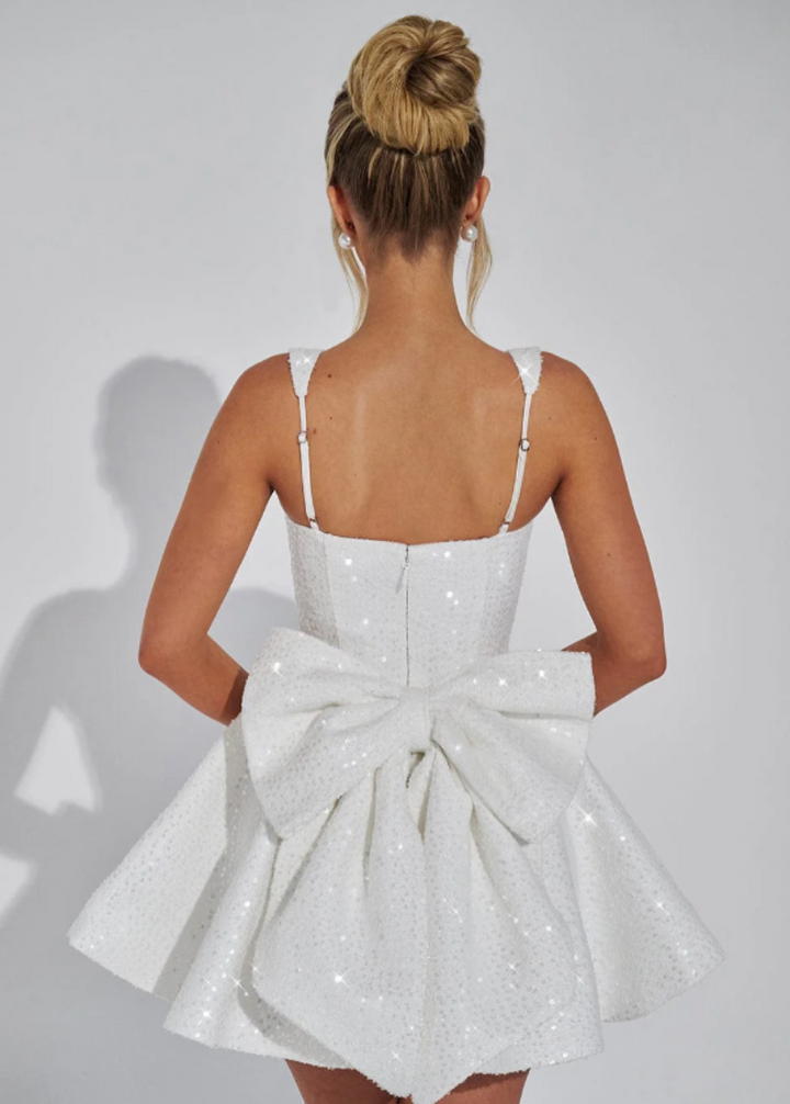 Glamorous women's sequin skater dress in pink, featuring a bow and perfect for dancing all night.