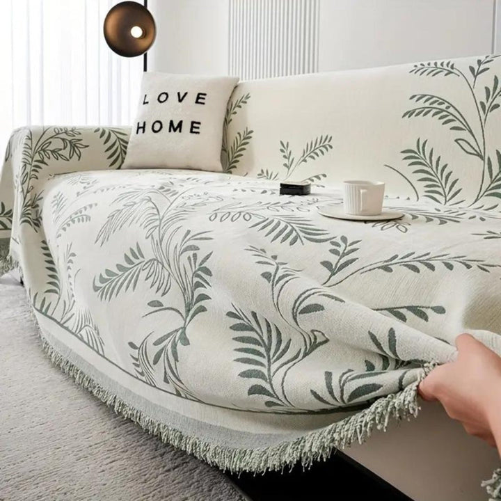 Luxury chenille sofa protector in dark blue with neat tassels, enhancing living room aesthetics.