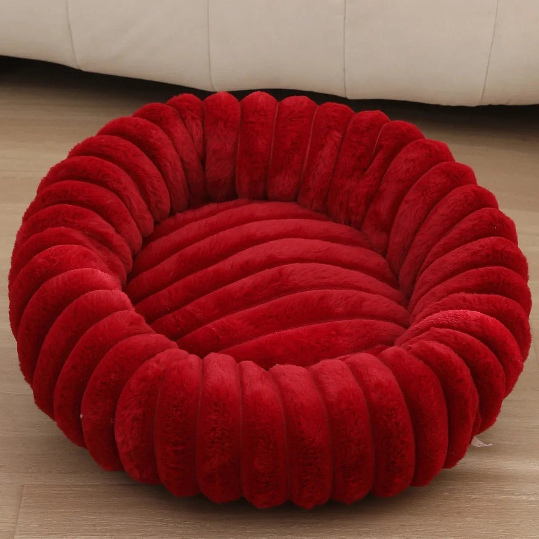 Gray plush calming dog bed, donut-shaped, a durable and comfortable sleep spot for pets.