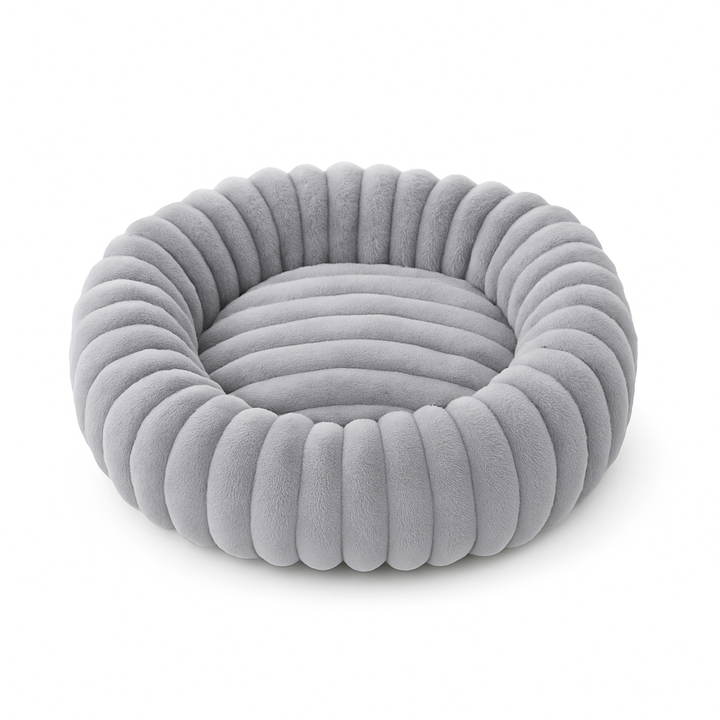 Soft, washable plush donut dog bed providing comfort for anxious small dogs.