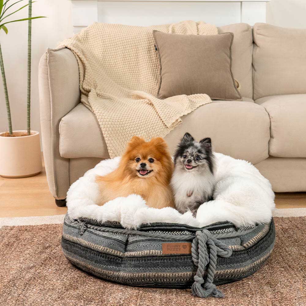 Small dog bed, plush donut design in light brown, with a deep sleeping area.
