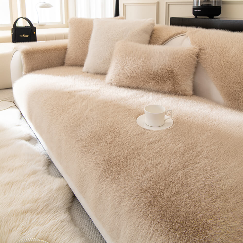 Full view of a living room sofa with a plush faux fur non-slip sofa cover installed.