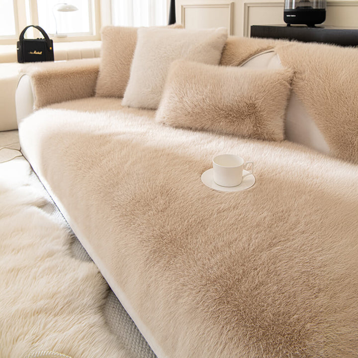 Full view of a living room sofa with a plush faux fur non-slip sofa cover installed.