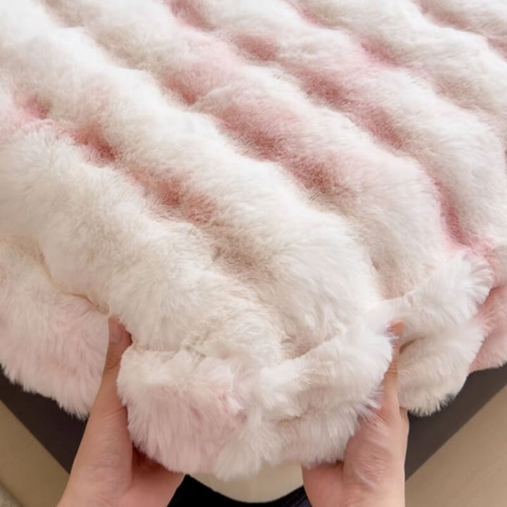 Detail shot of plush faux rabbit fur texture on a white mattress protector