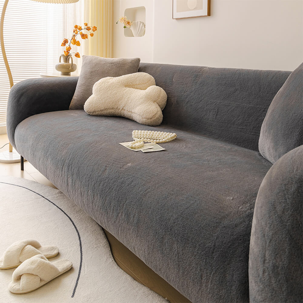Full view of a couch protected by a plush, stretchable sofa cover, showcasing its snug fit.