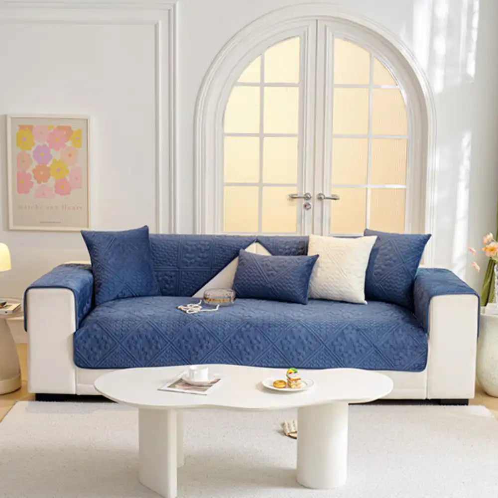 Corner of a sofa showcasing the snug fit of the quilted geometric plush couch cover.