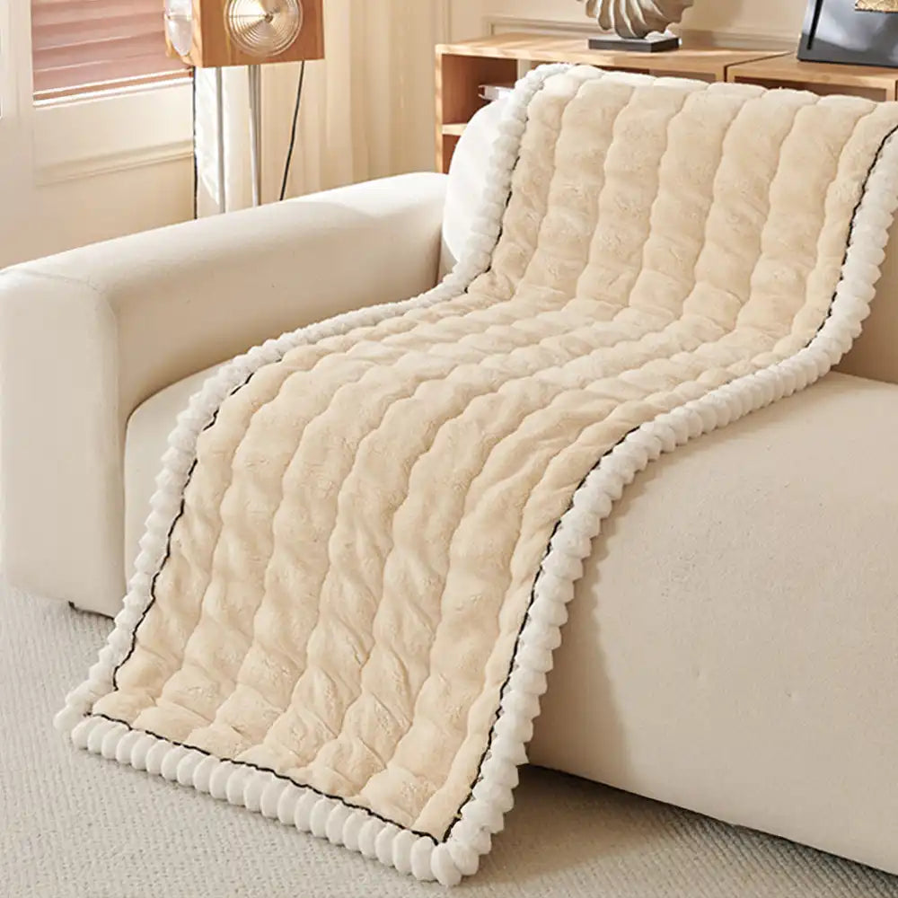 Fluffy grey couch cover draped loosely over a sofa, cozy home decor.