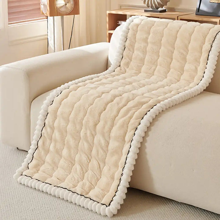 Fluffy grey couch cover draped loosely over a sofa, cozy home decor.
