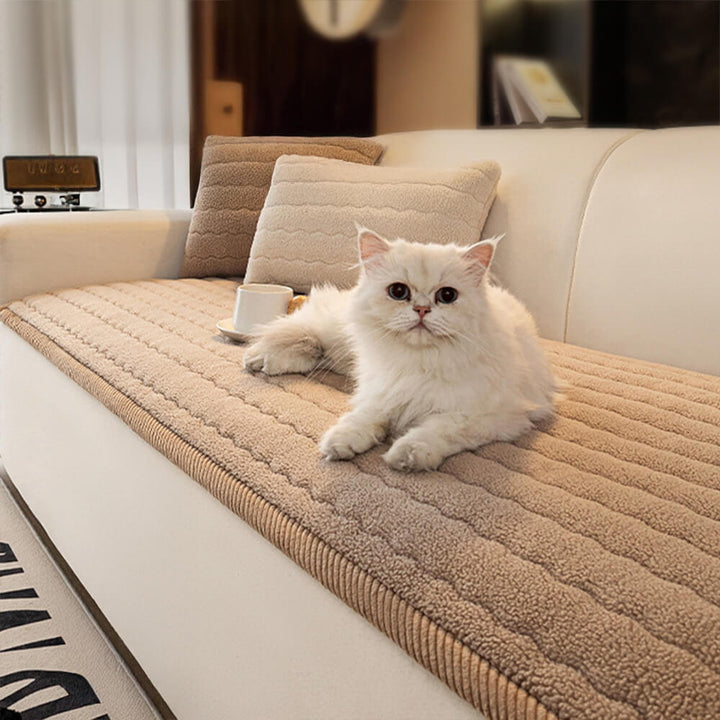 Plush lambskin feel sofa cover draped over a grey sectional couch in a living room