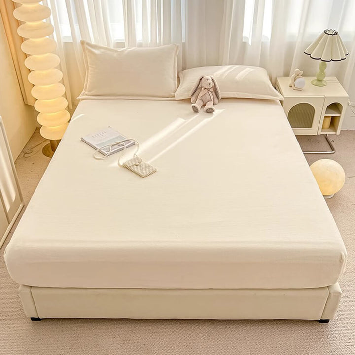 Soft milk velvet fitted sheet and matching pillowcases set for luxurious bedroom decor.