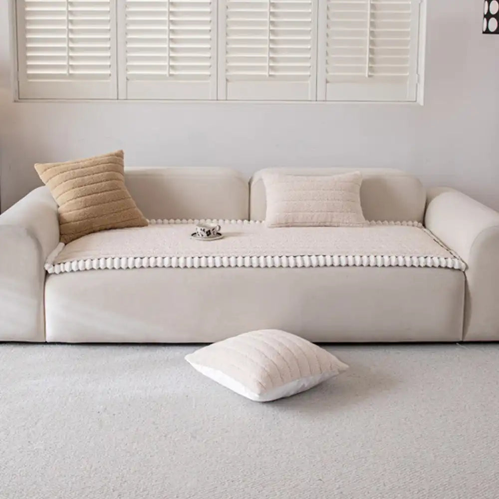 Overhead shot of a full living room with a cream non-slip sofa cover on the main couch.