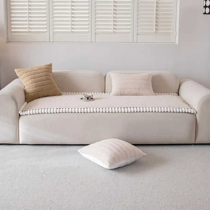 Overhead shot of a full living room with a cream non-slip sofa cover on the main couch.