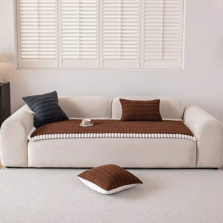 Before and after view: old sofa transformed by a snug-fitting non-slip navy blue couch cover.