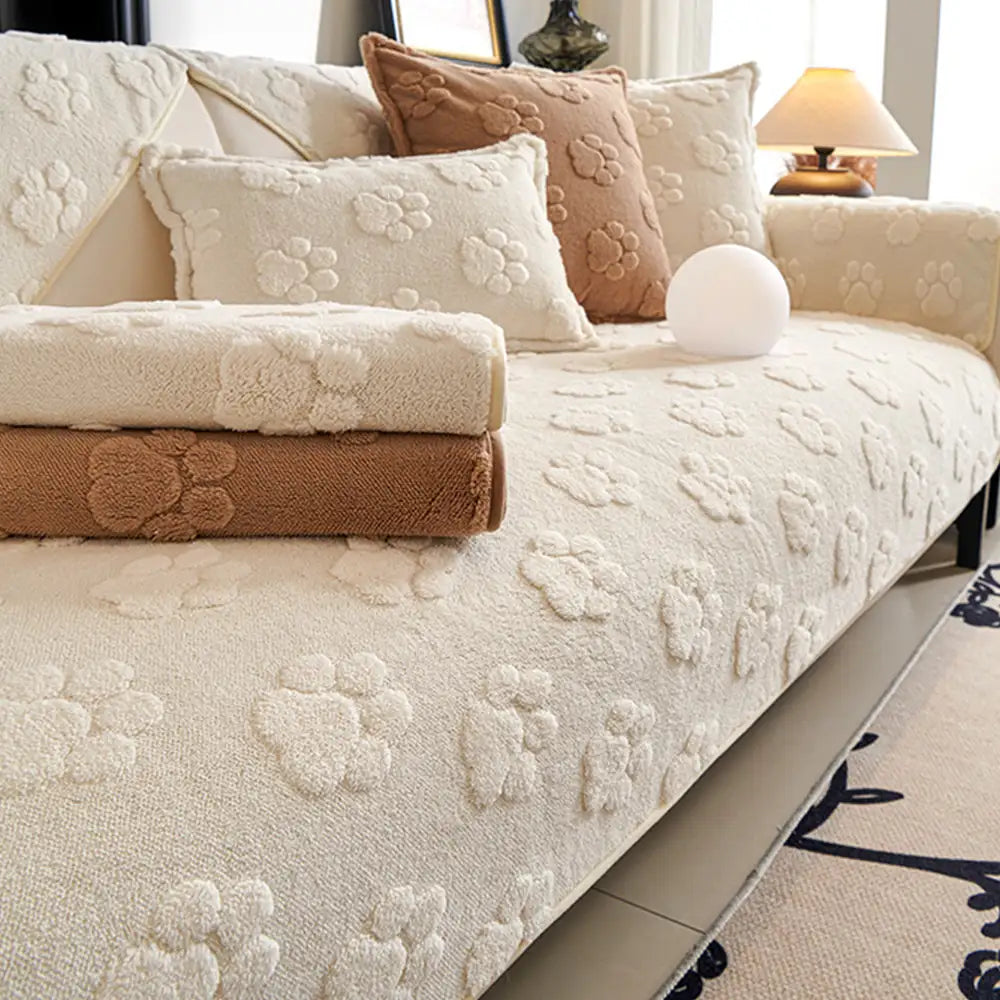 Thick plush couch cover with subtle paw prints, offering non-slip furniture protection