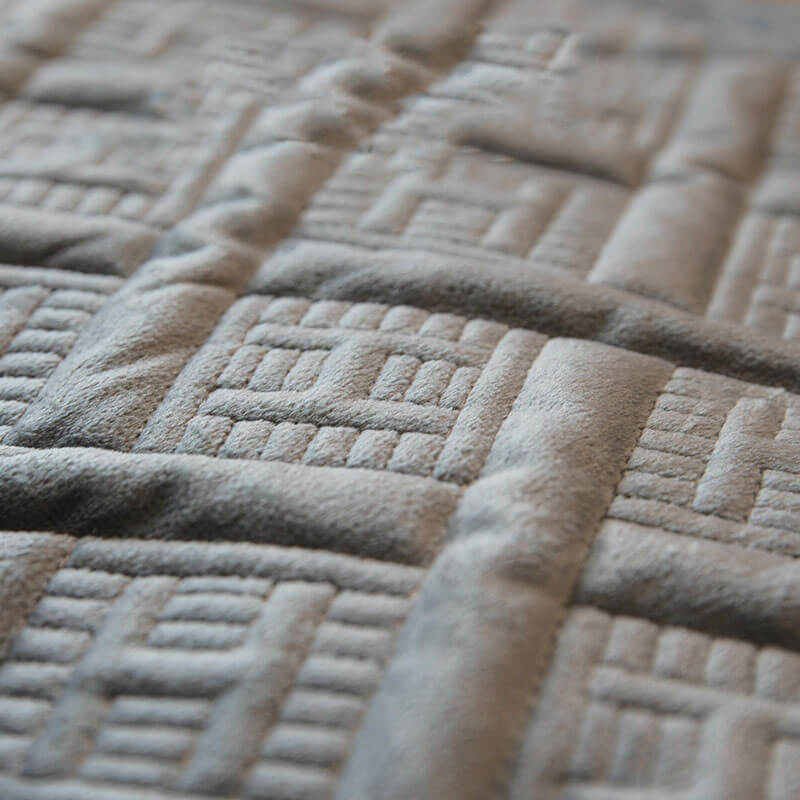 Beige quilted velvet sofa cover featuring durable stitching, ideal for a cozy living room aesthetic