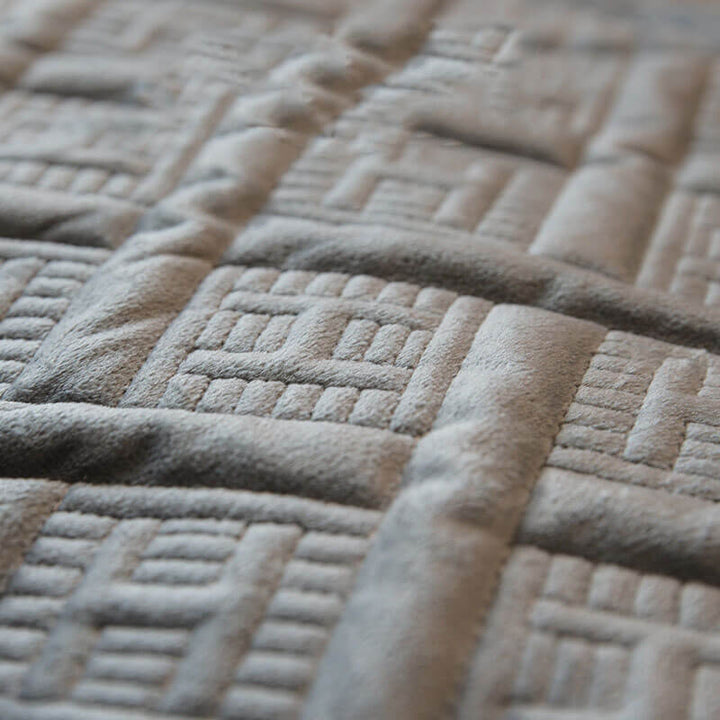 Beige quilted velvet sofa cover featuring durable stitching, ideal for a cozy living room aesthetic