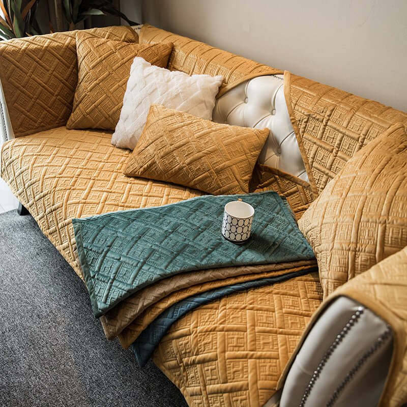 Unisex quilted velvet sofa cover protecting a light-colored couch, perfect for homes with pets