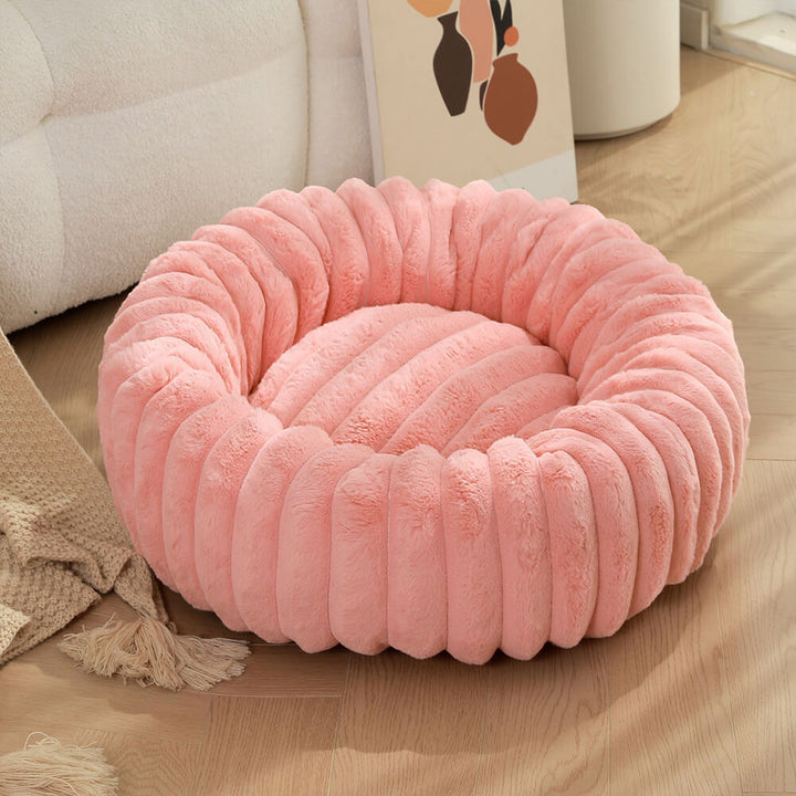 Plush round pet bed with an owner petting their dog, emphasizing the bed's calming comfort.